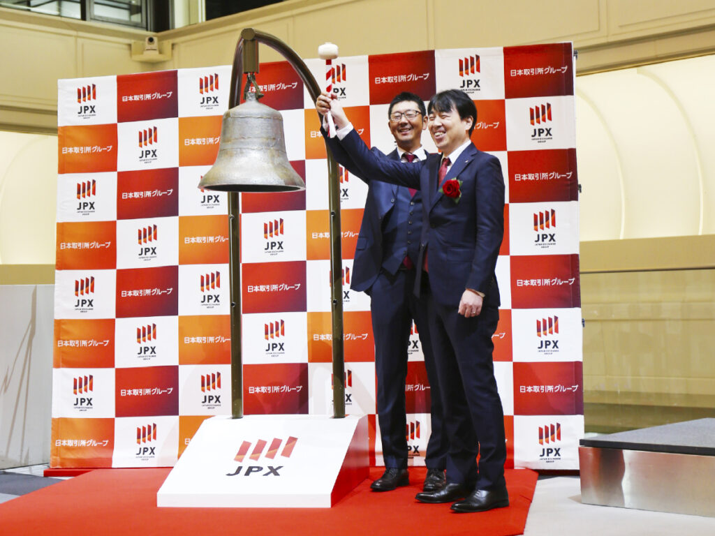 打鐘する代表取締役社長の大知昌幸と常勤監査役の根岸由次